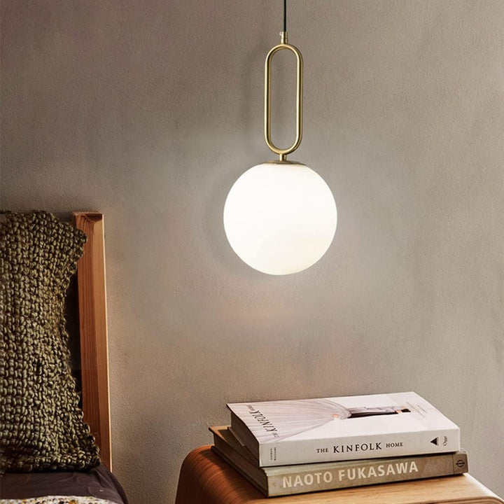Modern ball pendant hanging light installed beside bed, adding stylish ambient lighting to contemporary bedroom