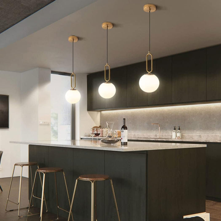 Baoden modern ball pendant light hanging above kitchen table, featuring sleek design and warm ambient lighting