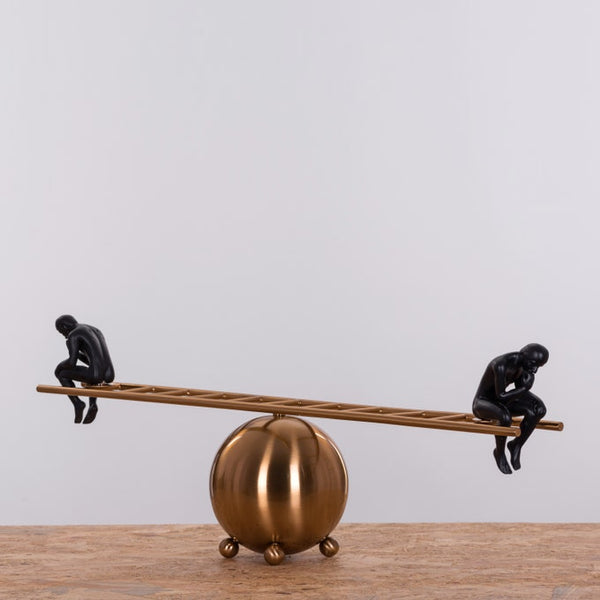 Pair of black thinker statues positioned on a decorative ladder, modern artistic home decor