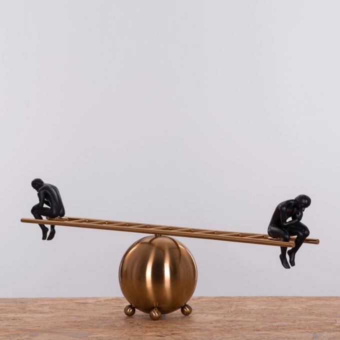 Pair of black thinker statues positioned on a decorative ladder, modern artistic home decor