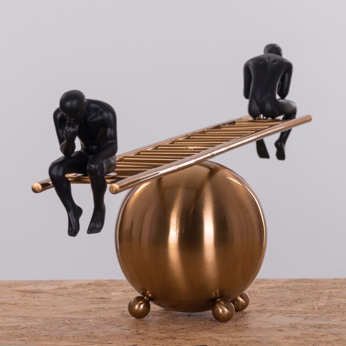 Close-up view of black thinker statues pair on decorative ladder showcasing detailed craftsmanship and modern artistic style