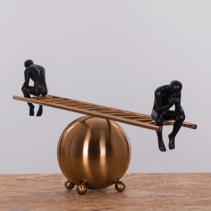 Side view of black thinker statues pair on decorative ladder highlighting modern artistic design and sculptural details