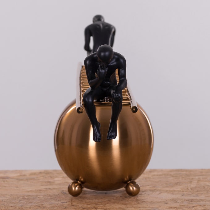 Decorative ladder with one black thinker statue seated, showcasing modern minimalist art design