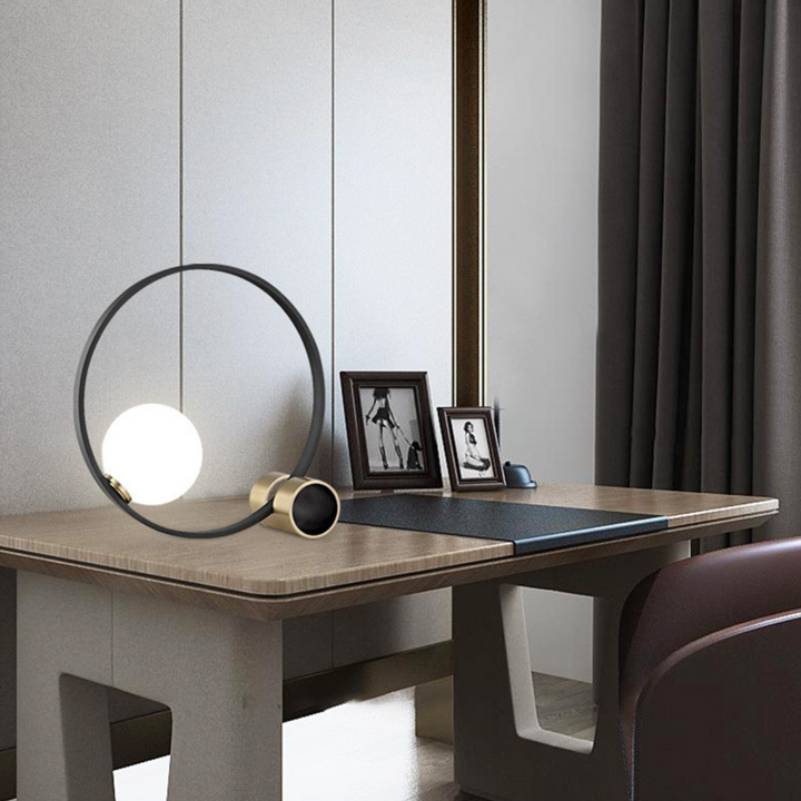 Bozza circle-shaped bedside table lamp on table, adding warm ambient light to modern bedroom decor