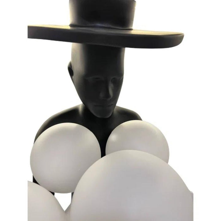 Close-up detail view of black human sculpture floor lamp with glowing orbs, highlighting modern design