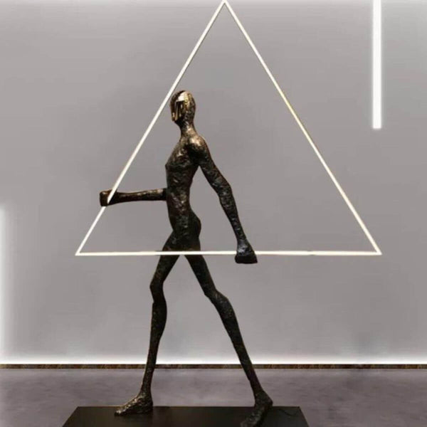 Side view of human statue floor lamp featuring a geometric triangle element, blending artistic sculpture with modern lighting design