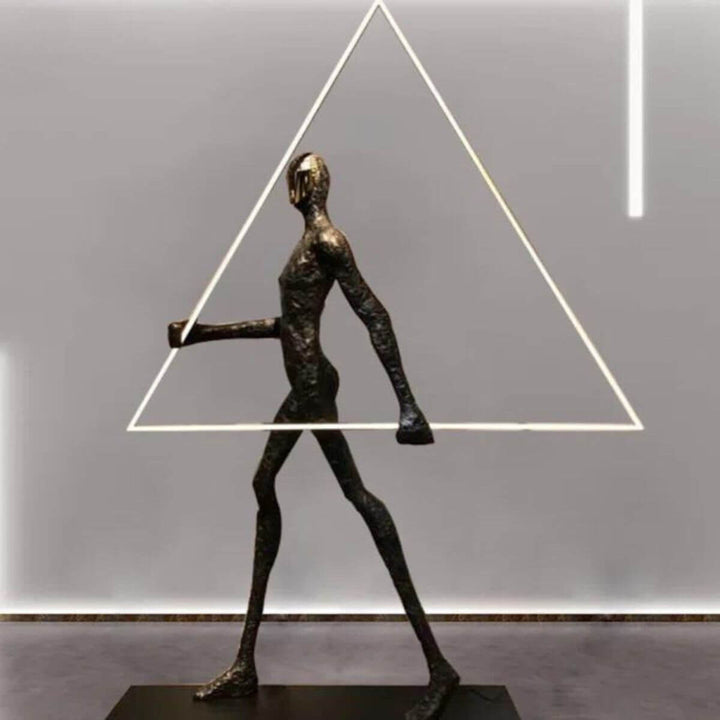 Side view of human statue floor lamp featuring a geometric triangle element, blending artistic sculpture with modern lighting design