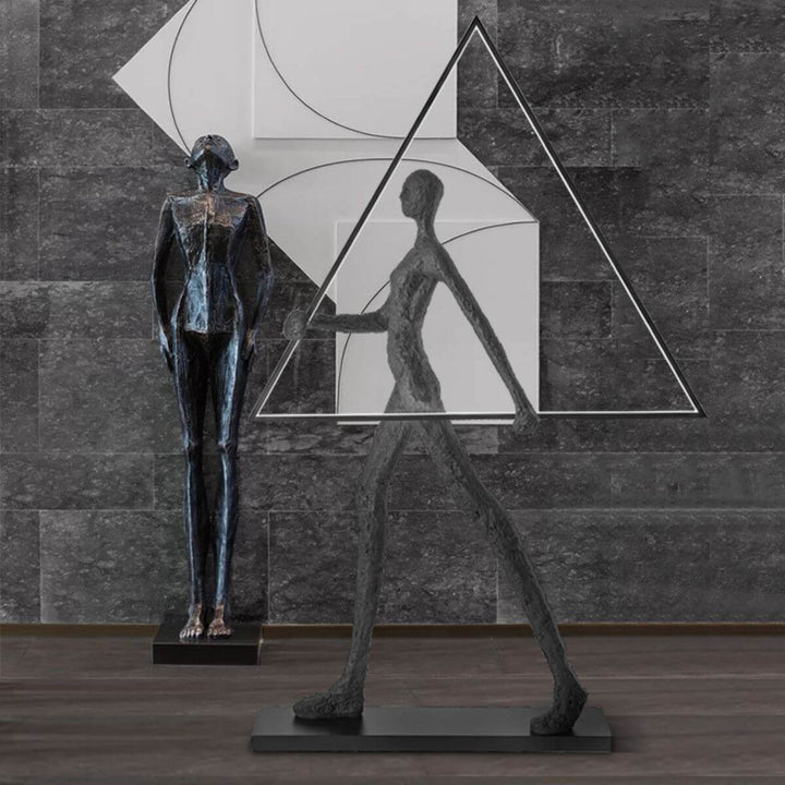 Side view of human statue floor lamp with geometric triangle design, showcasing sleek modern sculpture and warm ambient lighting
