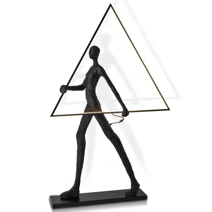 Elegant side view of human statue floor lamp featuring geometric triangle form and glowing ambient light