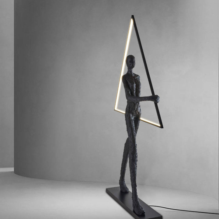 Front view of human statue floor lamp with geometric triangle element, highlighting its artistic design and modern ambient lighting
