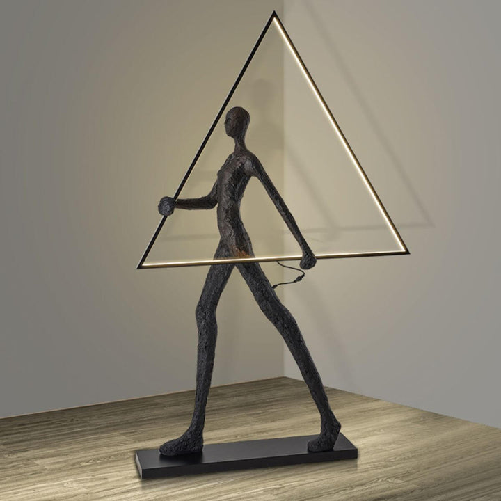 Side view of human statue floor lamp featuring a geometric triangle design, blending modern sculpture with ambient lighting