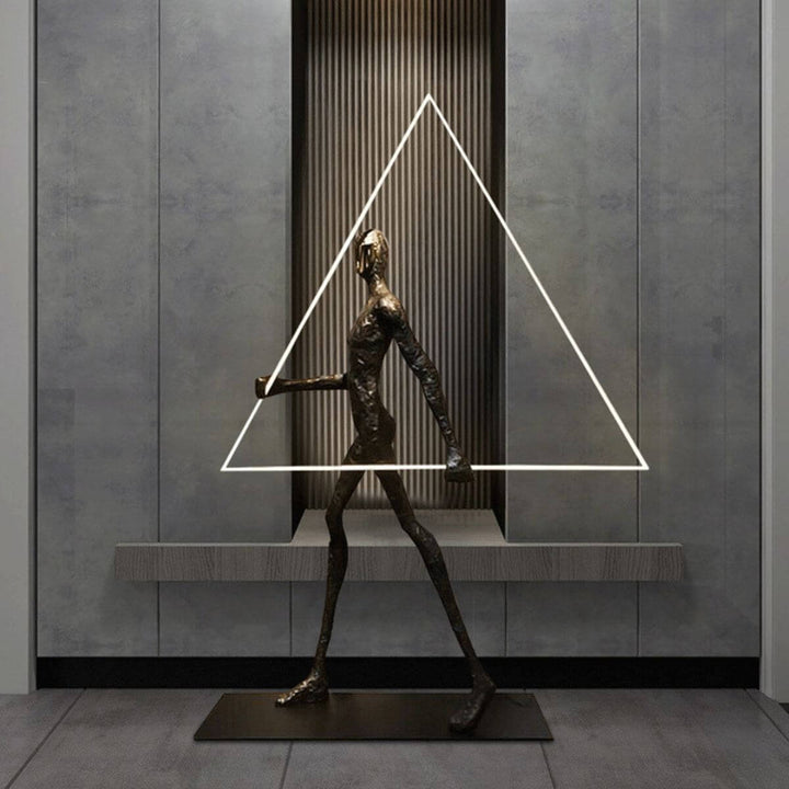 Side view of human statue floor lamp featuring a geometric triangle design, combining modern sculpture and ambient lighting