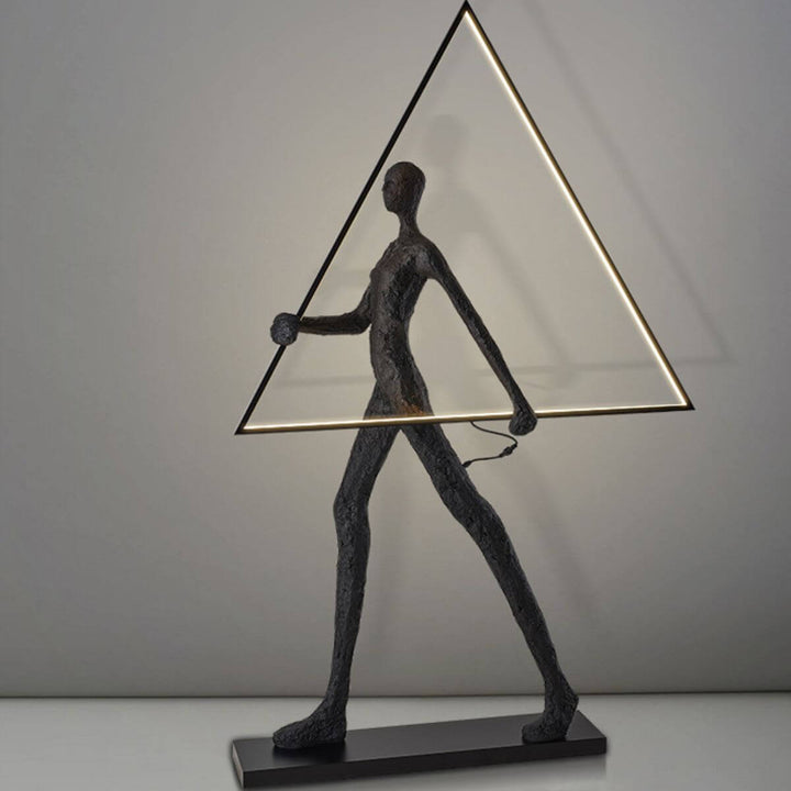 Side view of human statue floor lamp featuring a geometric triangle design, blending modern sculpture with warm ambient lighting