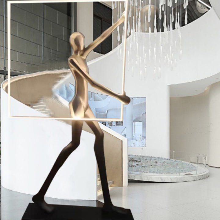 Romeo statue LED floor lamp positioned beside a staircase, featuring a sculptural figure and warm ambient lighting for modern interiors