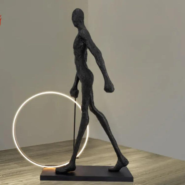 Side view of a man walking beside a circle LED floor lamp, highlighting the lamp’s glowing ring and modern interior design