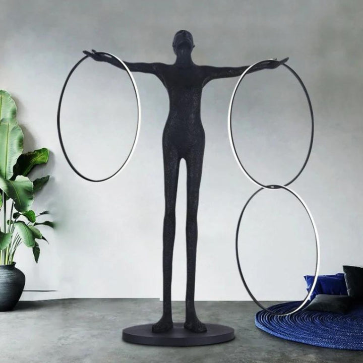 Human posing beside burning circle LED floor lamp, highlighting its sleek ring design and warm ambient lighting in a modern setting