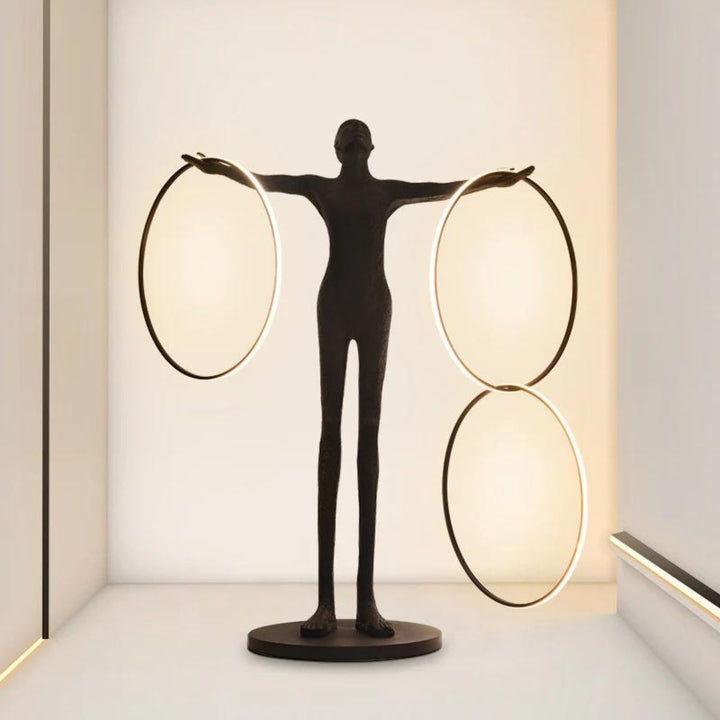 Human posing beside burning circle LED floor lamp with light turned on, showcasing warm ambient glow and sleek modern design