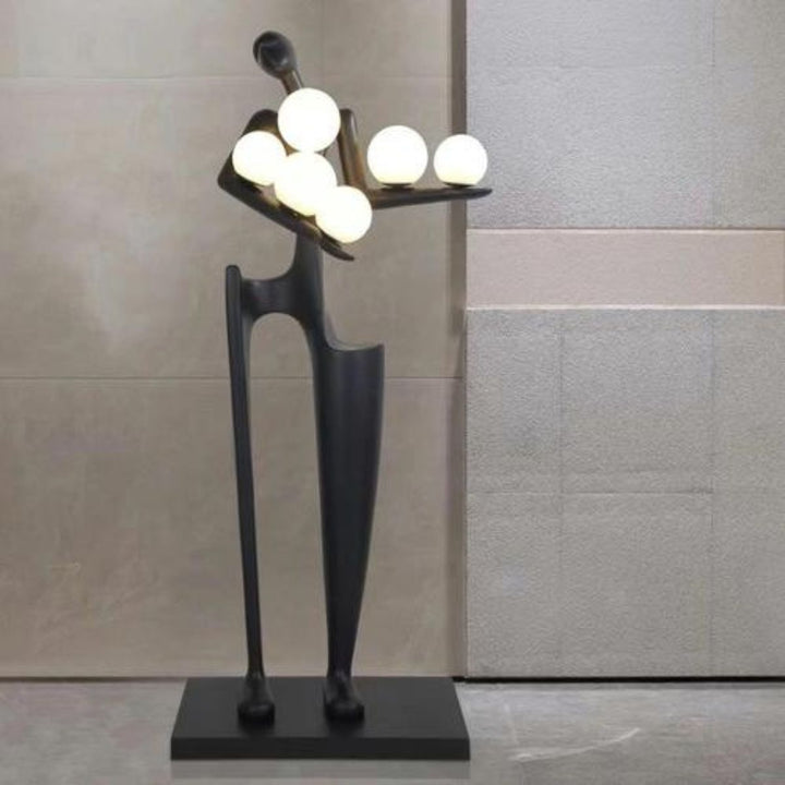 Dreamer black statue sculpture holding several glass globes, showcasing a blend of modern art and elegant design