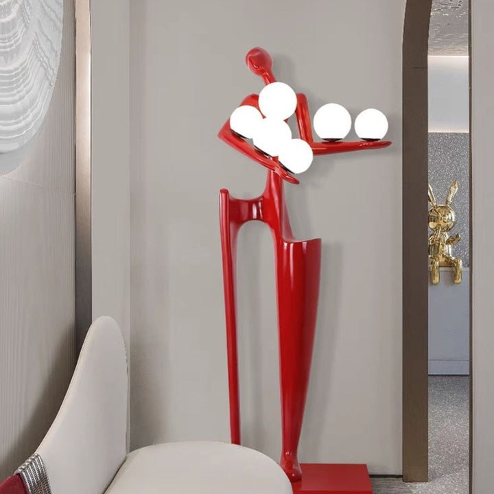 Dreamer red statue sculpture holding illuminated globes, featuring bold color and modern artistic design for stylish interiors