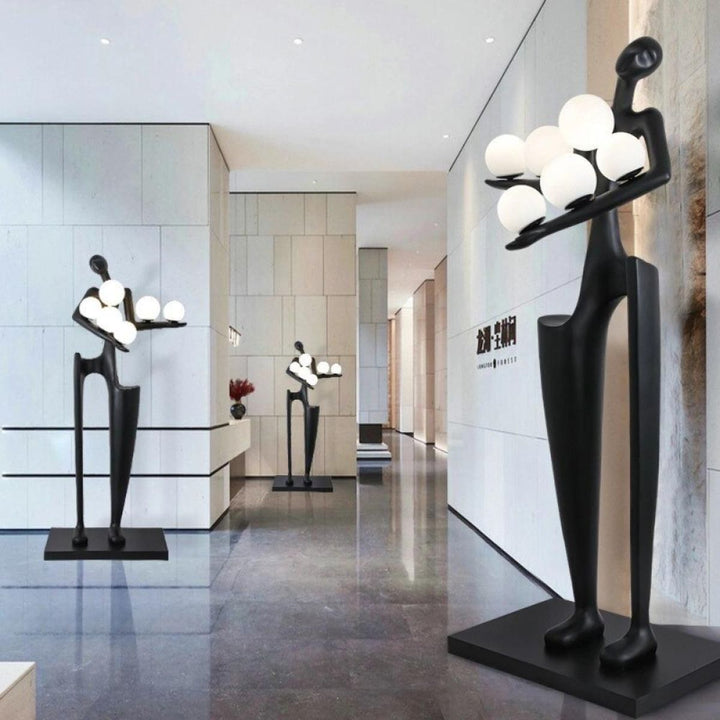 Dreamer black statue sculpture holding illuminated globes, featuring modern artistic design and ambient lighting
