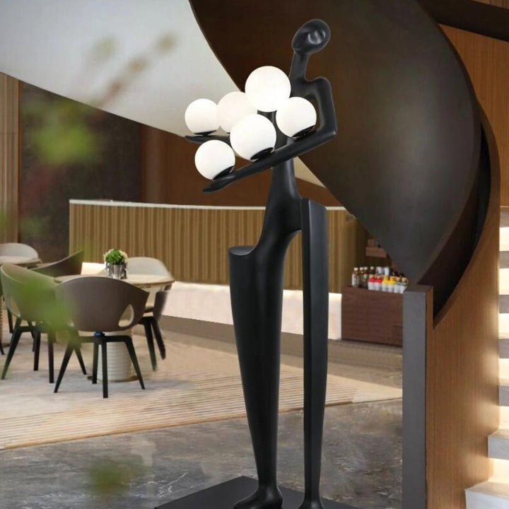 Dreamer black statue sculpture holding several glass globes, showcasing a blend of modern art and elegant design