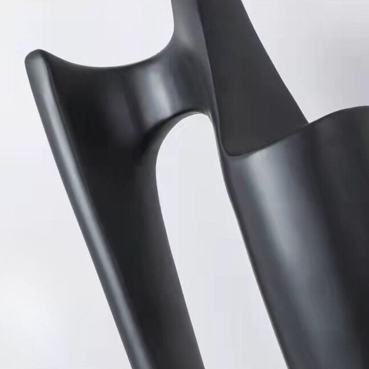 Close-up detail of the corner of Dreamer black statue holding globes, showcasing intricate sculptural craftsmanship and smooth finish