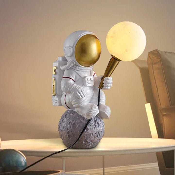 HTQ007 sitting astronaut table lamp turned on, emitting soft light with futuristic space design