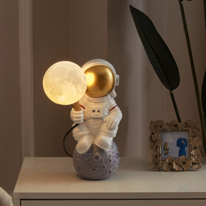 Front view of HTQ007 sitting astronaut table lamp turned on, showcasing futuristic space design