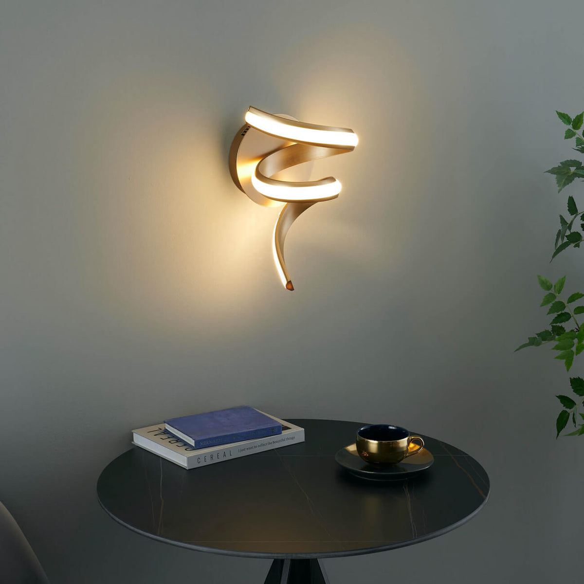 Lara gold spiral LED wall light installed on table side wall in elegant interior setting