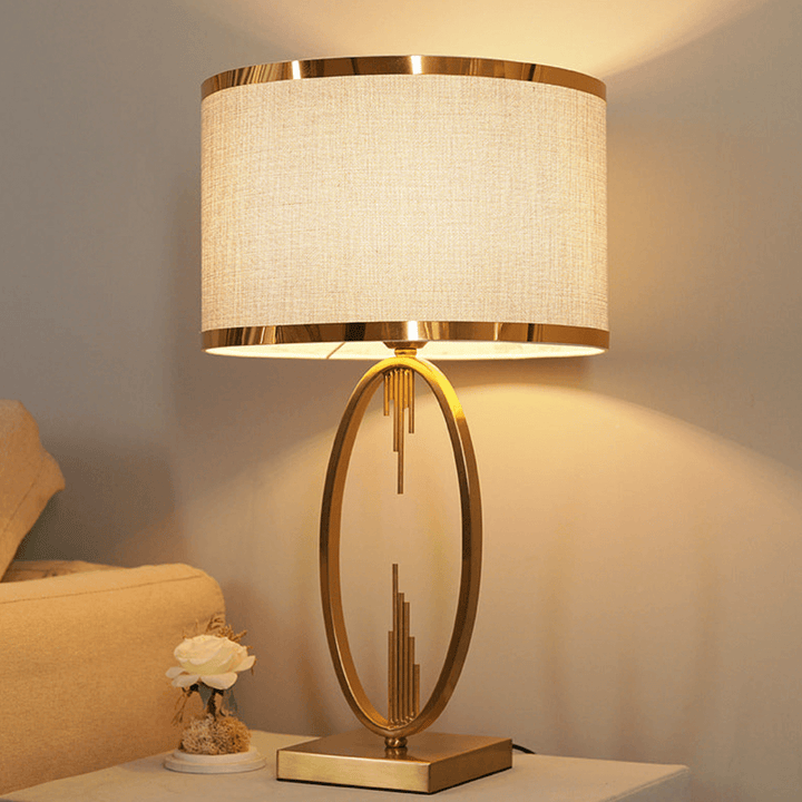 Modern copper bedside lamp glowing softly in cozy bedroom