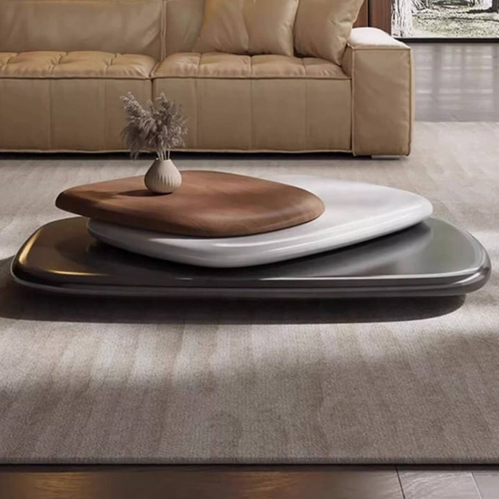 Pebble-shaped coffee table placed in front of sofa set, featuring smooth natural wood finish and rounded edges in modern living room