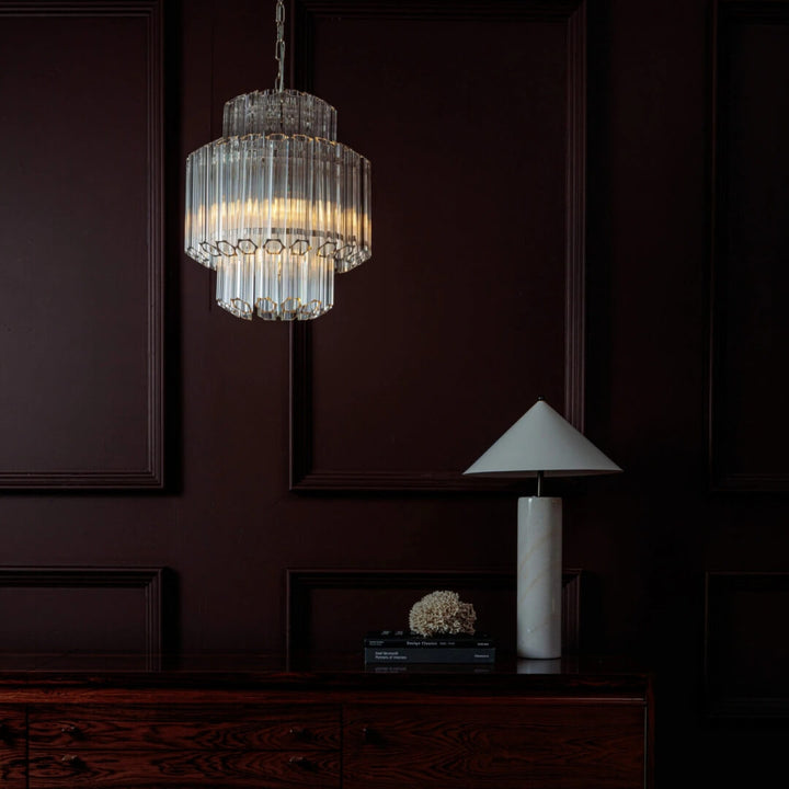 Piccolo Palermo chandelier hanging above living room table, providing elegant lighting and modern design