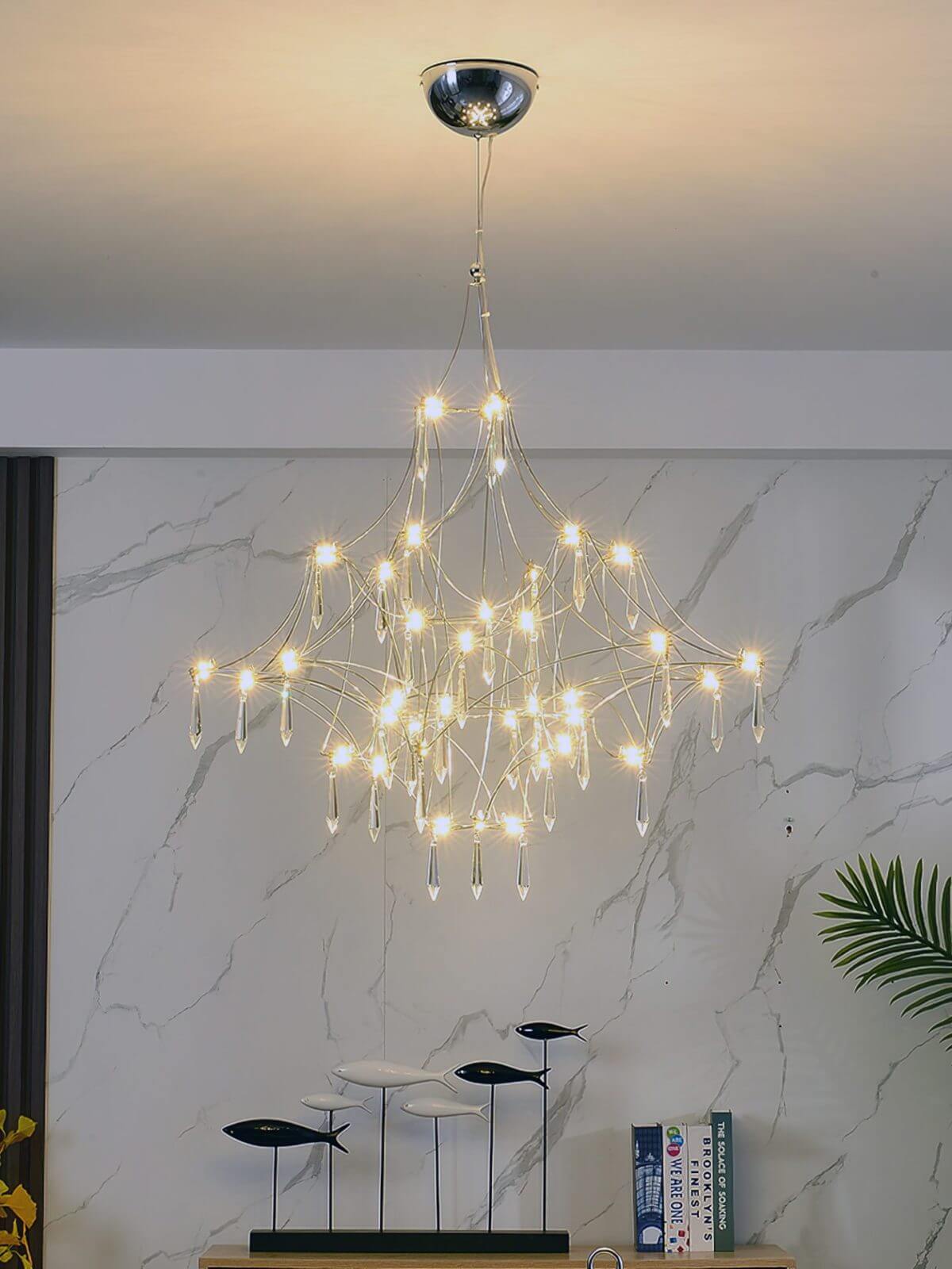 Prism premium Asfour crystal chandelier illuminated in elegant living room, casting sparkling light and enhancing luxurious ambiance