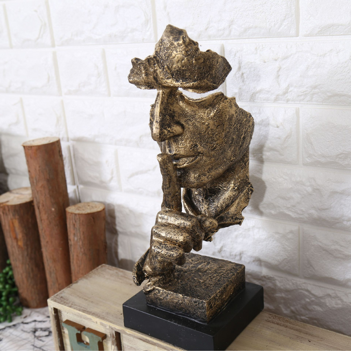 Resin half-faced sculpture titled Silence Is Golden with golden finish