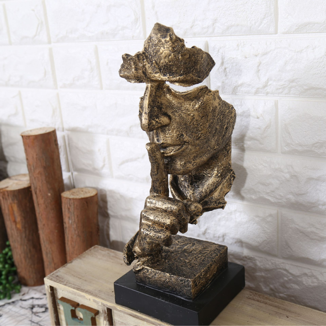 Resin half-faced sculpture titled Silence Is Golden with golden finish