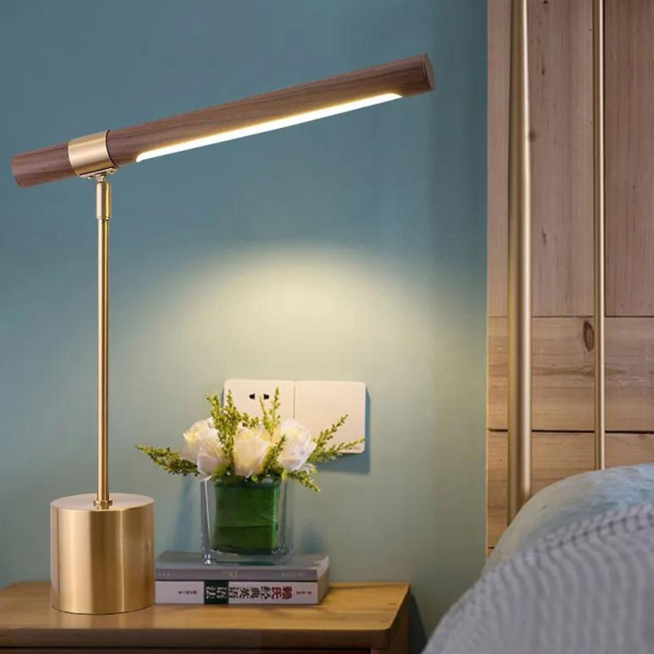 Stylish bedside lamp with walnut wood and metal base on nightstand next to bed