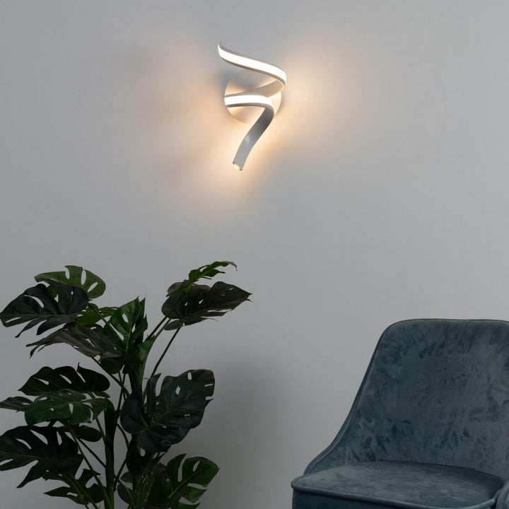 White LED spiral ribbon wall light Lara installed on side wall in elegant interior setting
