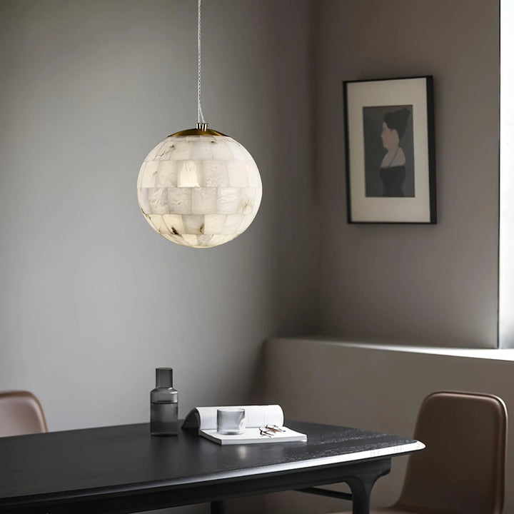 Alabaster ball pendant light above reading table, modern ceiling fixture for stylish home décor