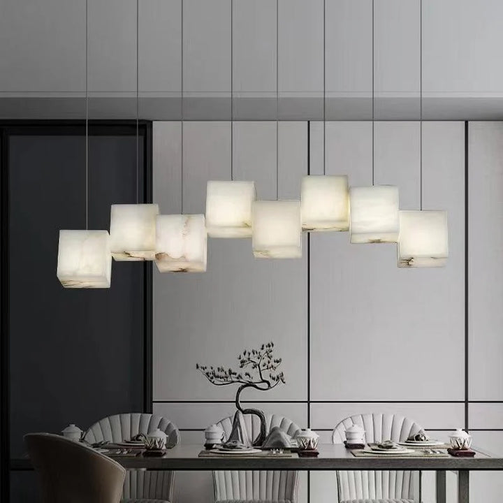 Alabaster box chandelier lighting above a luxury dining room, adding elegance and a warm glow to the space