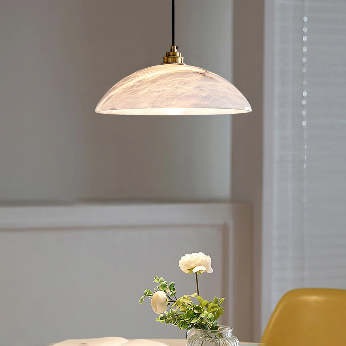 Alabaster dome pendant lamp above dining table, modern lighting decor for stylish interiors