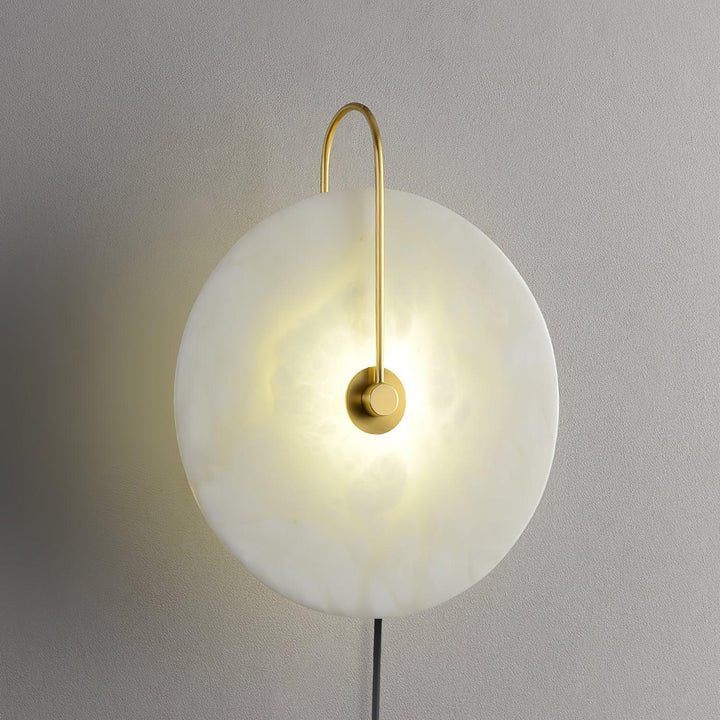 Side view of alabaster LED plug-in wall lamp showing stone texture and warm diffused light.