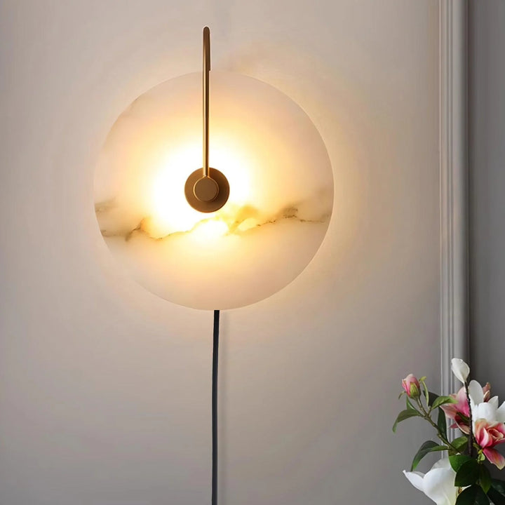 Front view of alabaster LED plug-in wall lamp with natural veining and warm diffused light