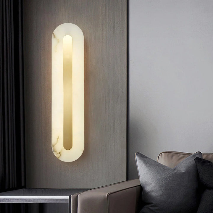 Alabaster rounded marble wall light beside sofa in living room, modern lighting decor