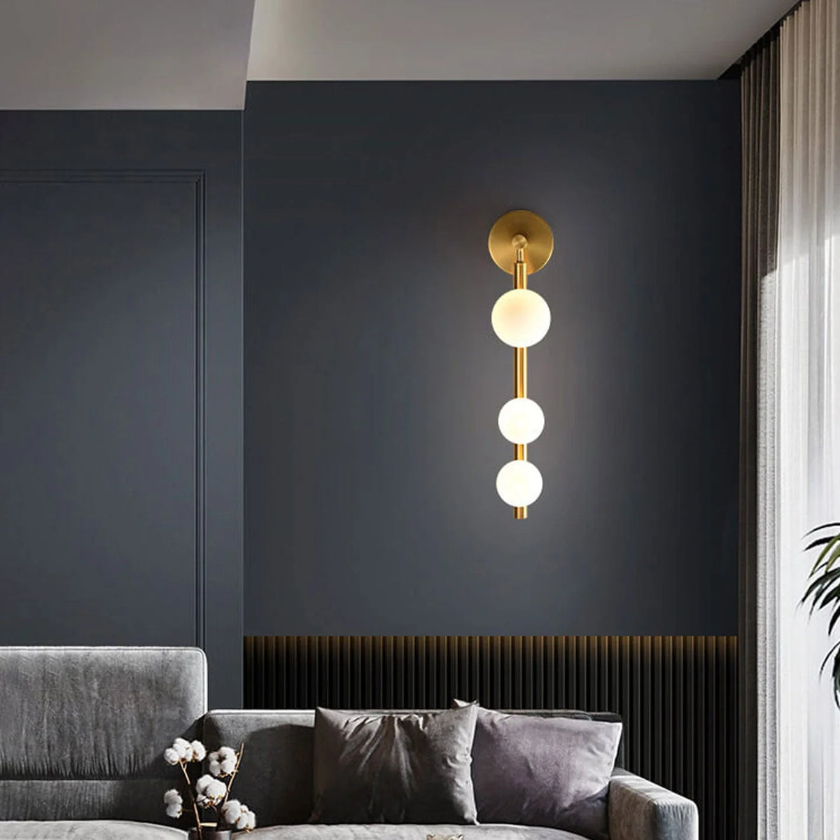 Aurora Trio Globe Wall Sconce light installed in living room, modern metal and glass design with G9 bulb