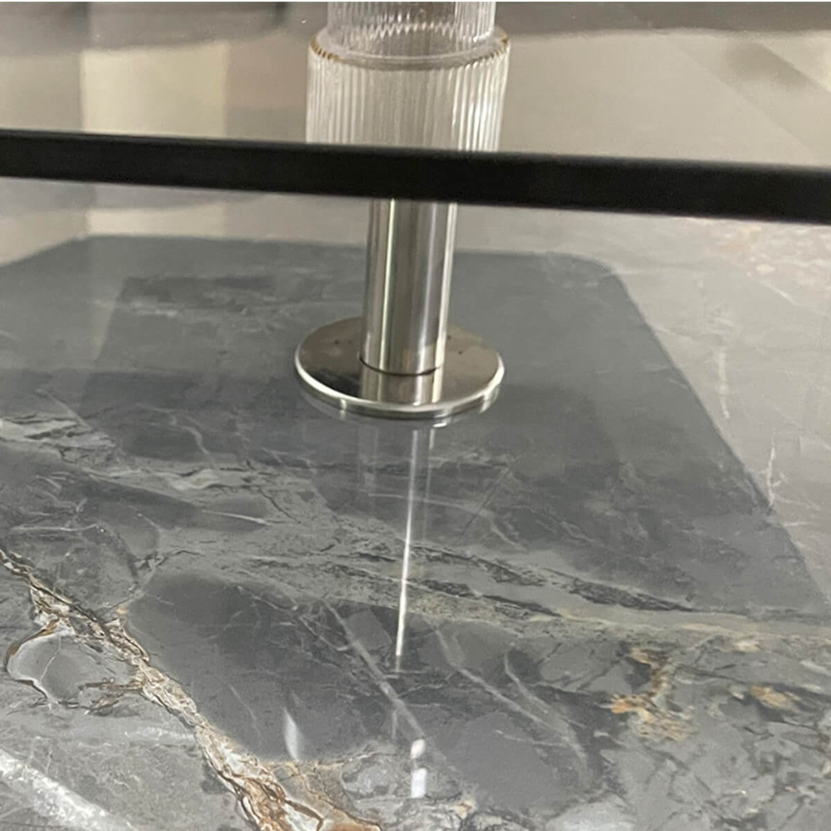 Close-up detail view of Blanco coffee table’s toughened glass stand with marble top, highlighting craftsmanship