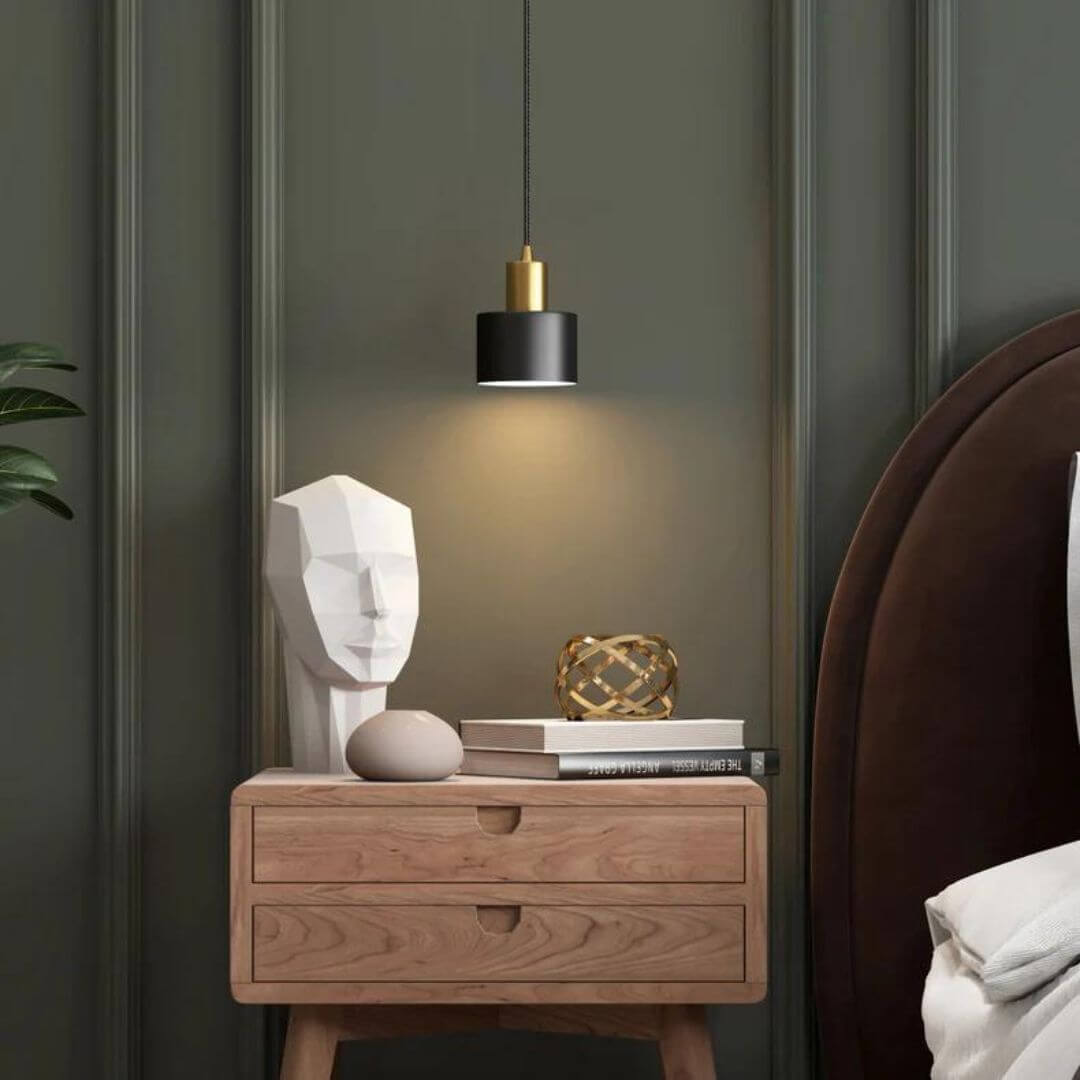 Modern Brilliance chandelier with metal and glass design hanging above bedroom table, adding sleek elegance