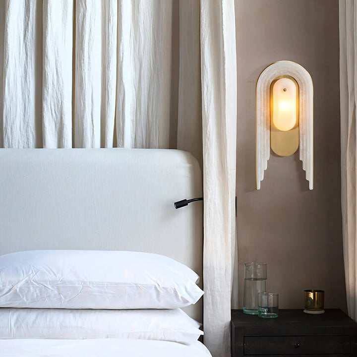 Cascada wall sconce bedside view with alabaster shade and gold metal accent, modern lighting