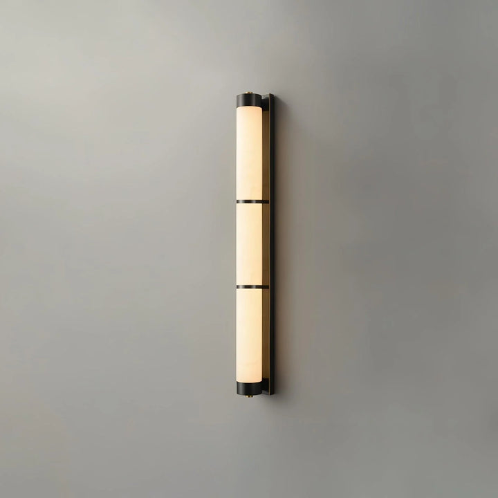 Cylindra alabaster brass wall light with black finish shown from front view in modern elegant interior