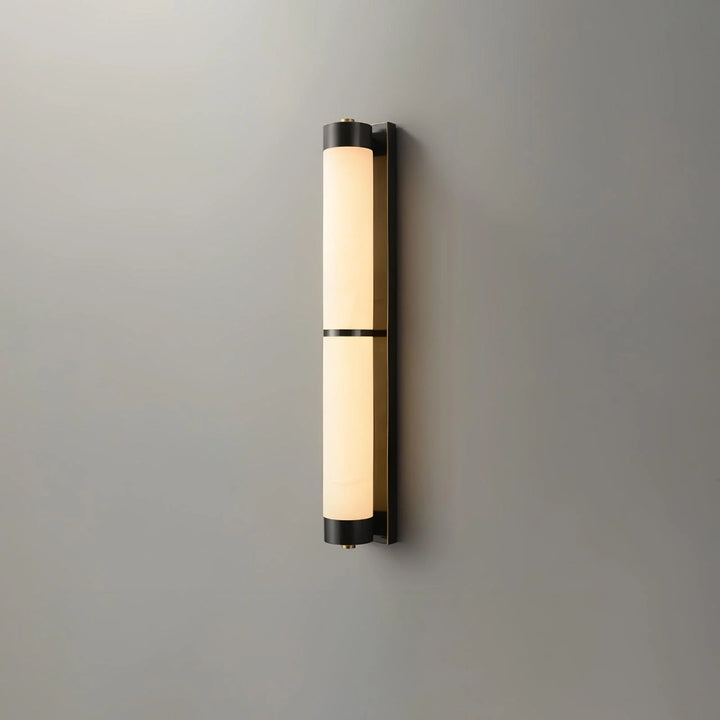Cylindra alabaster brass wall light shown from front view in sleek modern interior setting