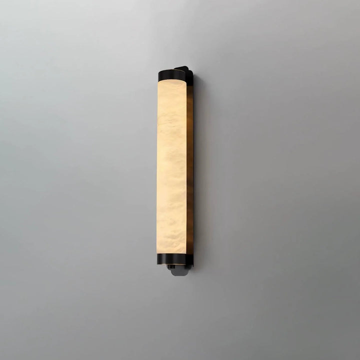 Cylindra alabaster brass wall light shown from side view, highlighting elegant modern design in interior setting